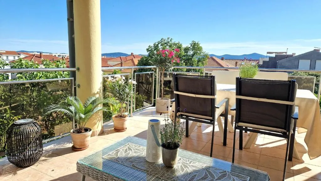 Penthouse panoramic terrace with a table and city view