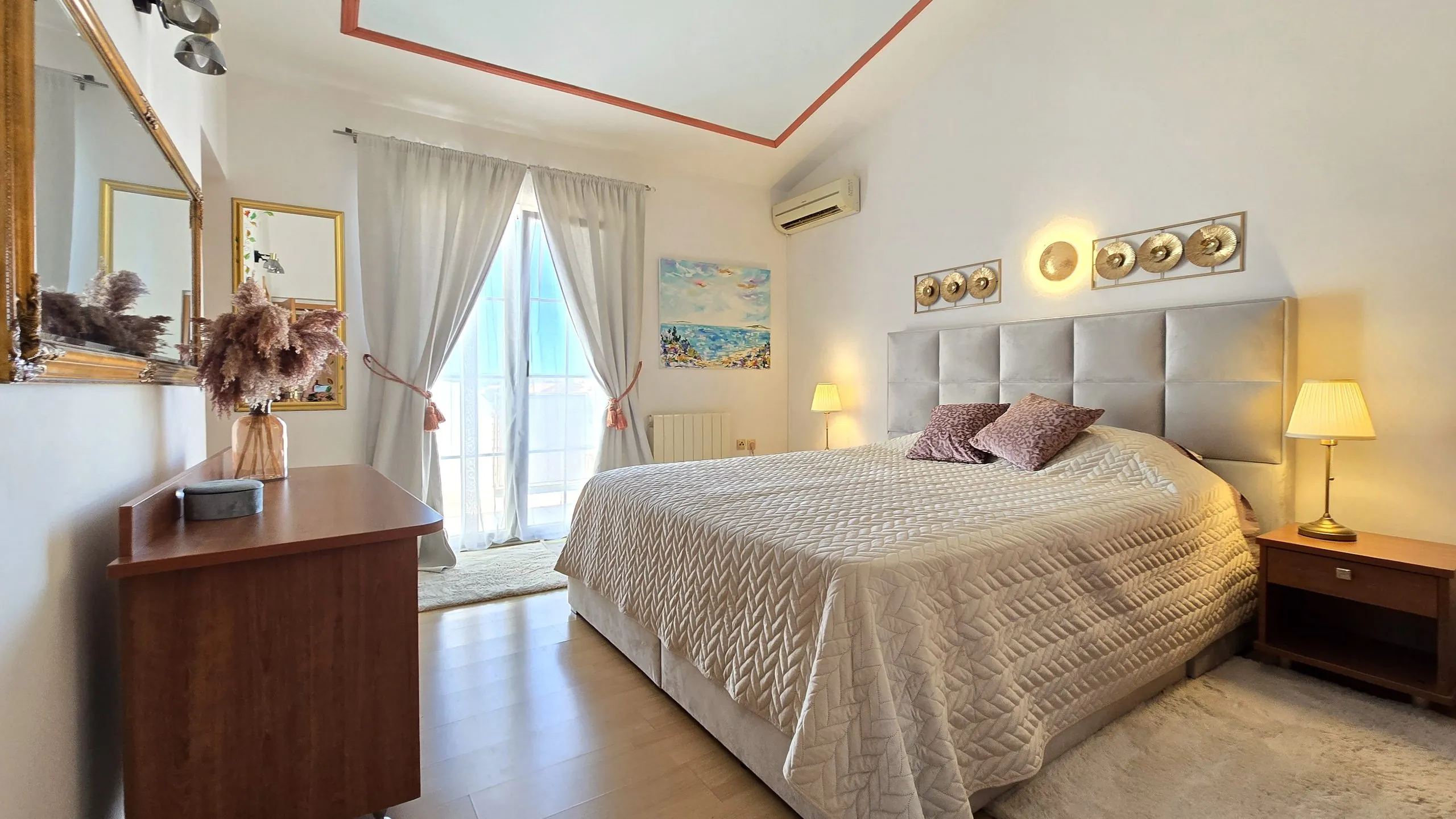 Bright penthouse bedroom with a double bed and balcony doors