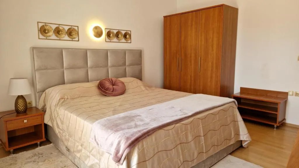 Bedroom with golden wall decorations and a wooden wardrobe