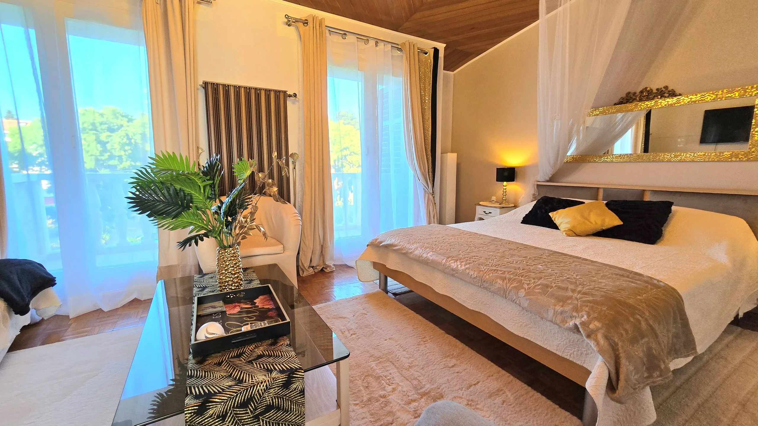 Deluxe triple room with a large double bed and seating area