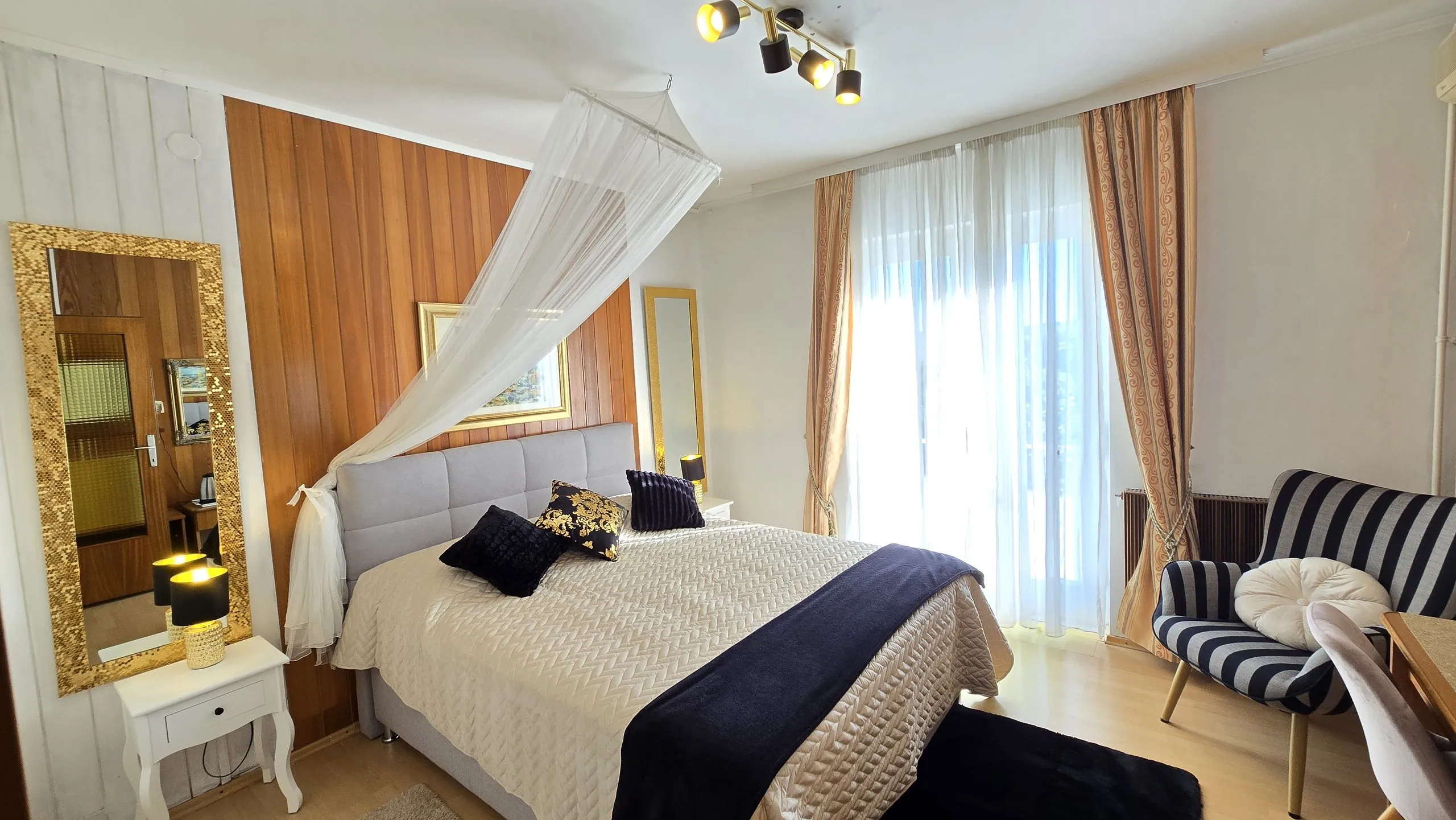 Double room with a canopy double bed and armchair