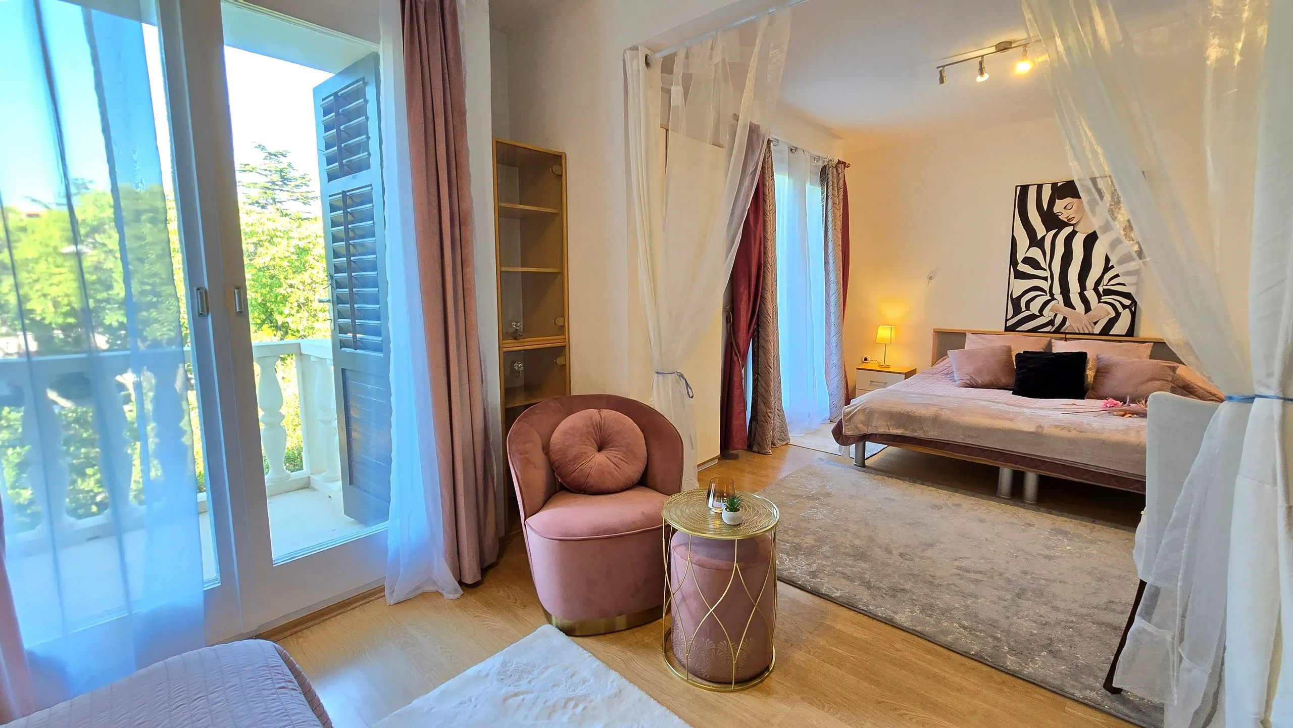 Standard quadruple room with balcony access and a seating corner