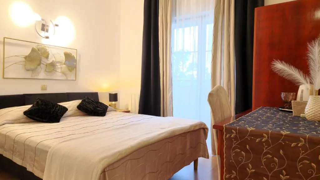 Room with a double bed and a table for two