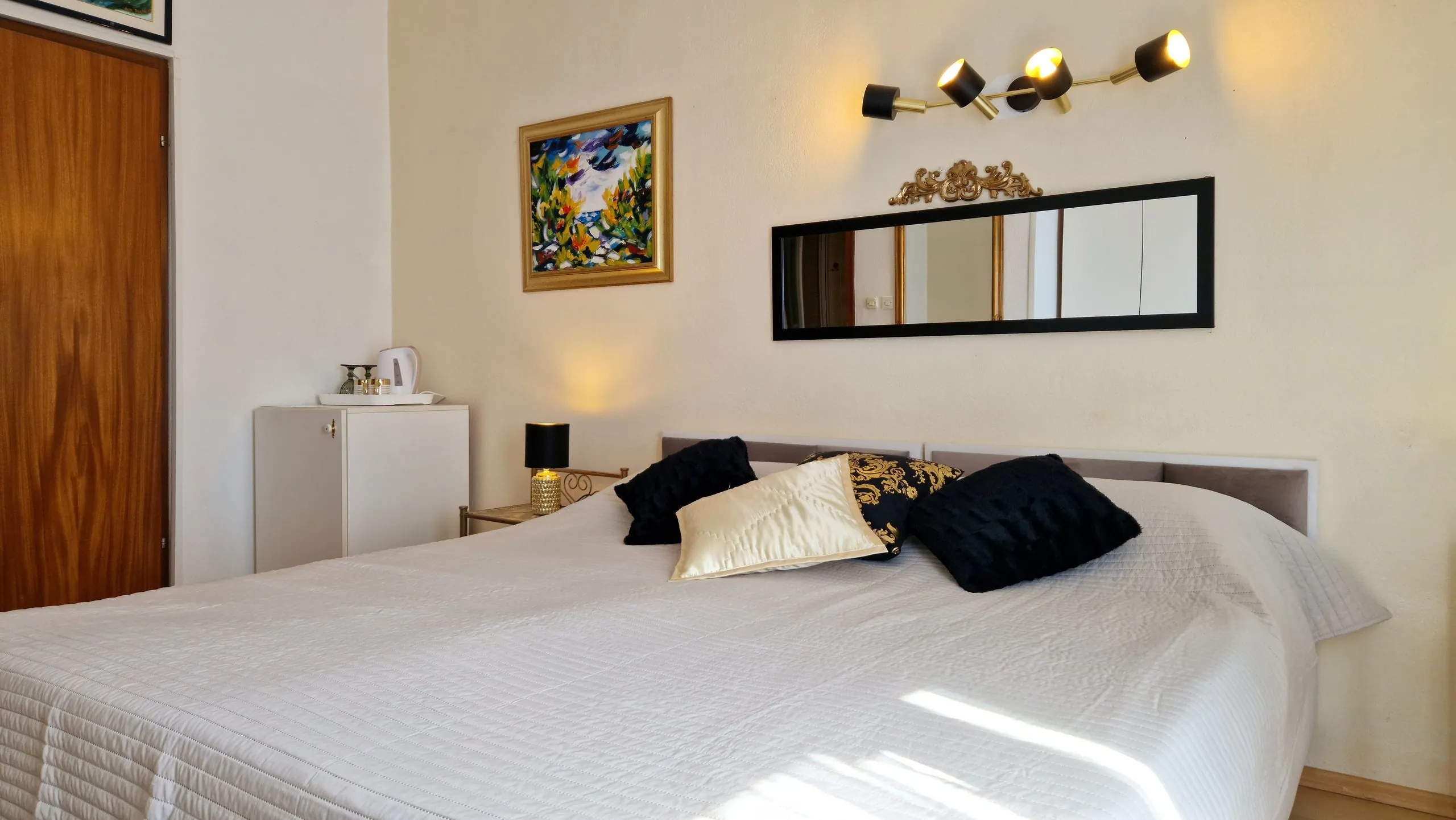 Double room with a double bed, fridge and original painting