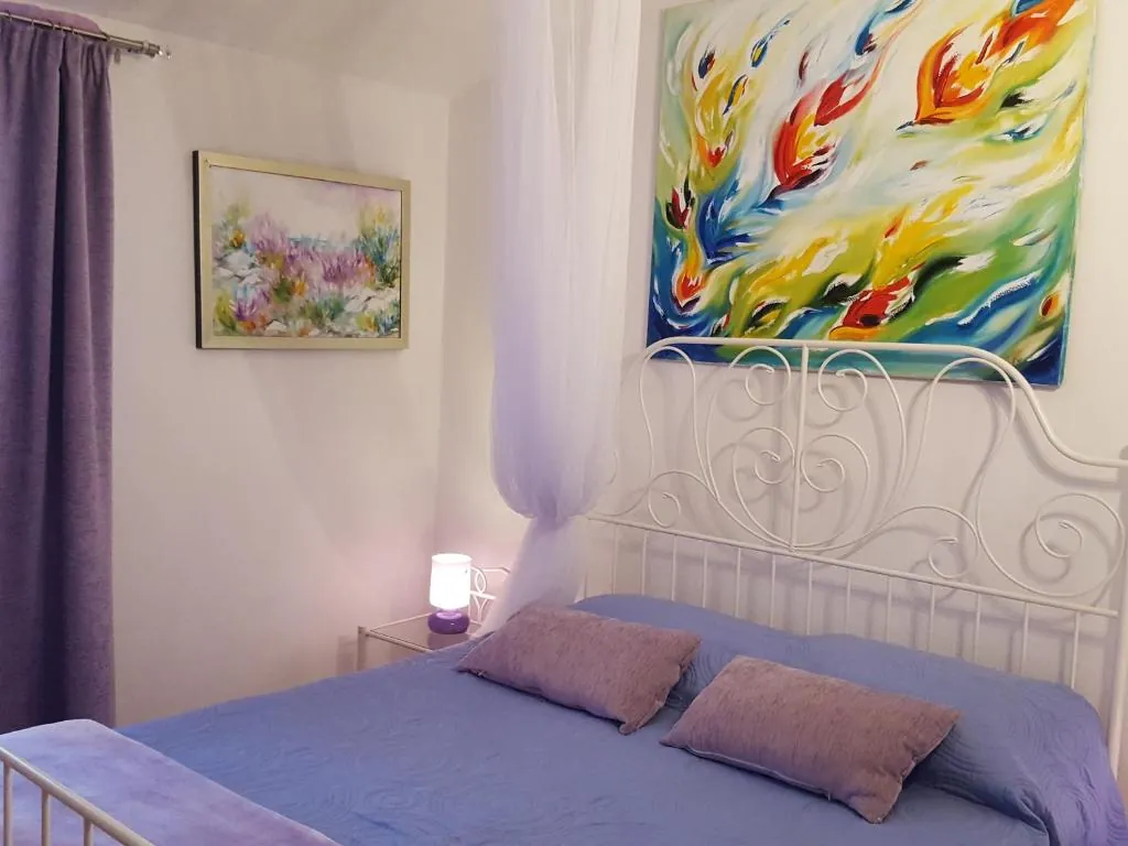 Suite with a wrought-iron bed and a large abstract painting