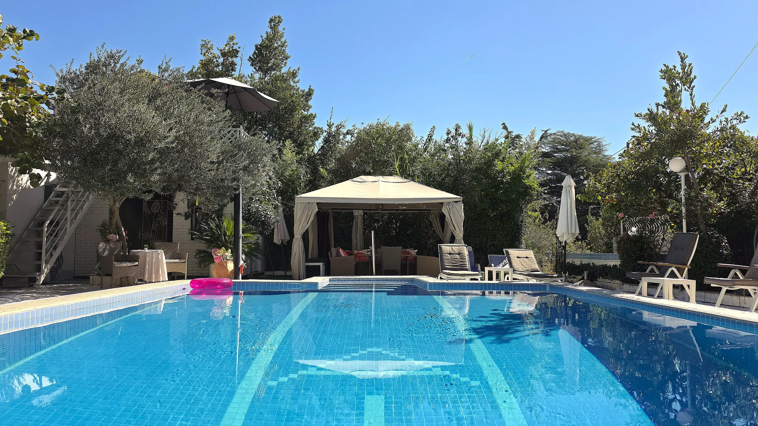 Outdoor pool surrounded by a Mediterranean garden, gazebos and parasols in Borik, Zadar