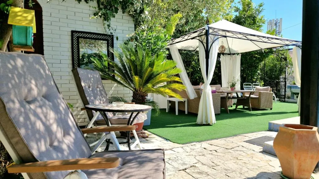 Shaded sun loungers and a gazebo with lounge furniture in the garden